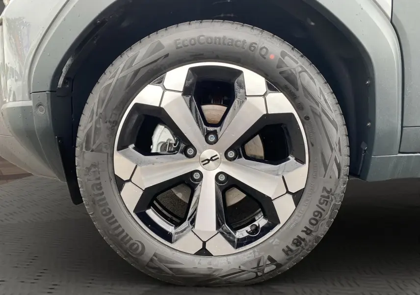 Gros plan sur la roue avant droite du Dacia Duster 2025 gris schiste avec jante alliage au design hexagonal.