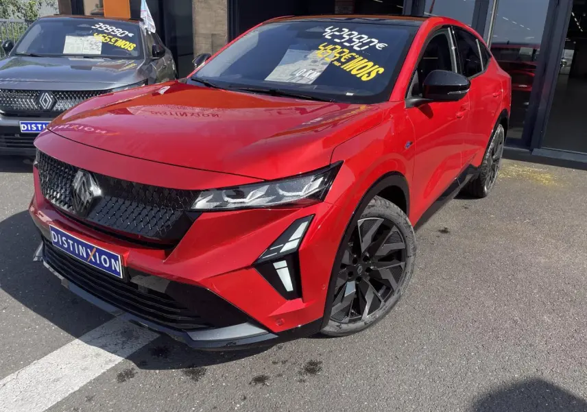 Vue 3/4 avant droite d’une Renault Rafale rouge flamme avec toit noir et jantes noires diamantées.