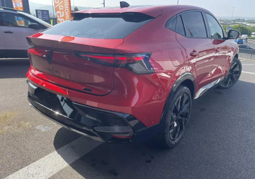 Vue 3/4 arrière droite d'une Renault Rafale rouge flamme avec toit noir et jantes alliage noires.