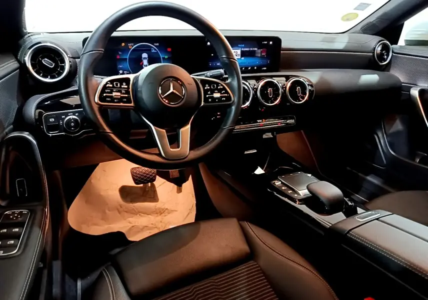 Intérieur noir de la Mercedes CLA 200 d Business Line 2021, vue de face sur le volant et le tableau de bord digital.