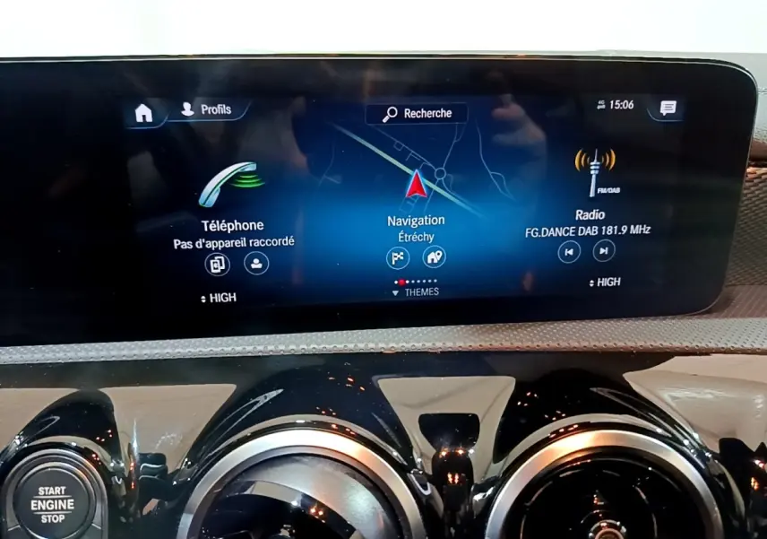 Vue rapprochée de l’écran tactile central et des aérateurs ronds noirs du tableau de bord de la Mercedes CLA 200 d Business Line blanche.