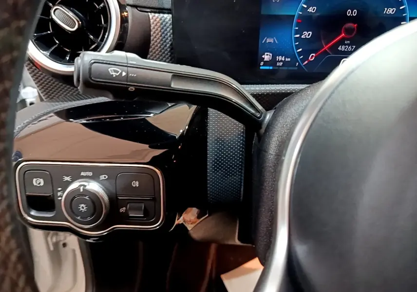 Détail du tableau de bord noir et volant partiel de la Mercedes CLA 200 d Business Line, avec commandes et écran digital.