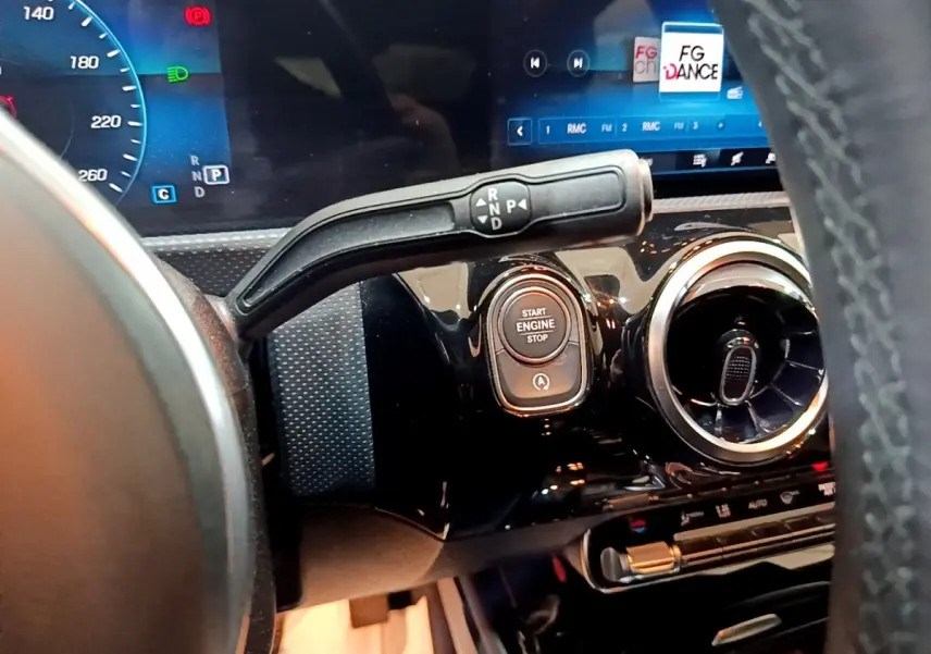 Gros plan intérieur sur le tableau de bord noir brillant de la Mercedes CLA 200 d, avec levier de vitesses et bouton démarrage.