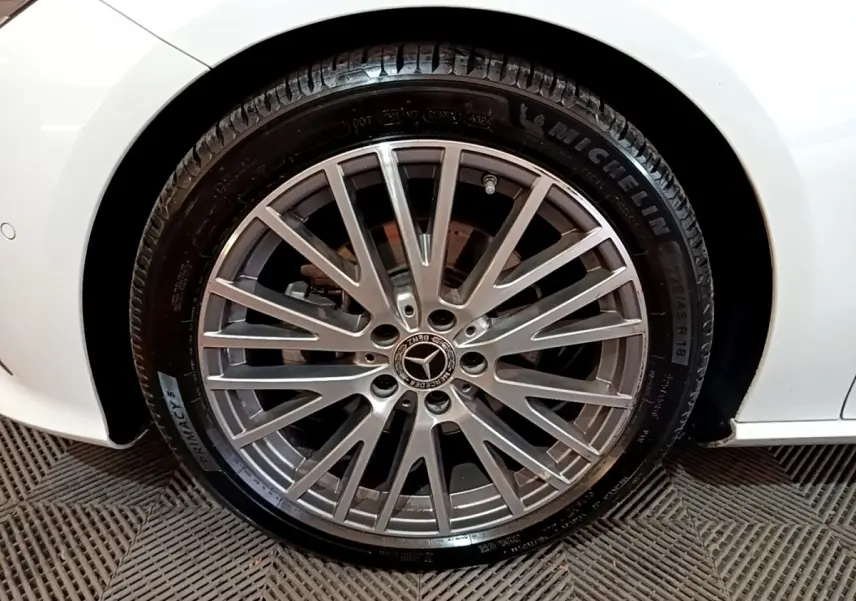 Gros plan sur la roue avant droite d’une Mercedes CLA 200 d Business Line blanche, jante alliage multi-branches.