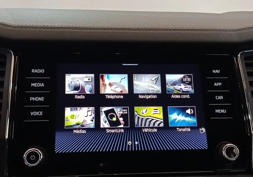 Écran tactile central du tableau de bord du Skoda Kodiaq blanc, affichant les options multimédia et navigation.