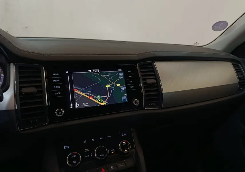 Tableau de bord intérieur du Skoda Kodiaq 2022, vue de côté droit avec écran tactile de navigation allumé.
