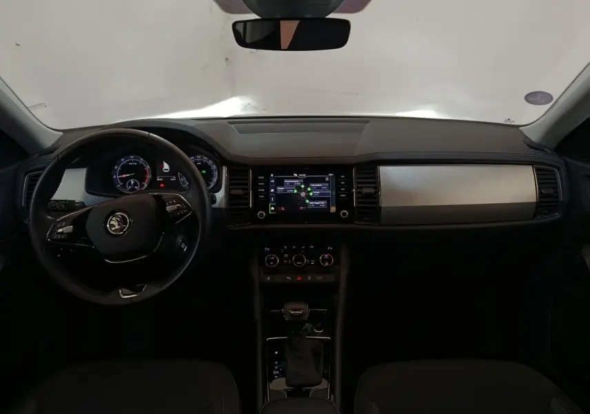 Vue intérieure frontale du tableau de bord noir du Skoda Kodiaq 2022 avec écran tactile central et volant multifonctions.