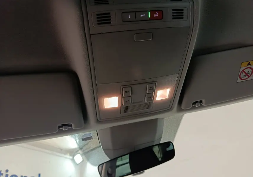 Plafonnier intérieur allumé avec commandes SOS et éclairage, vue centrée vers l'avant du Skoda Kodiaq blanc 2022.