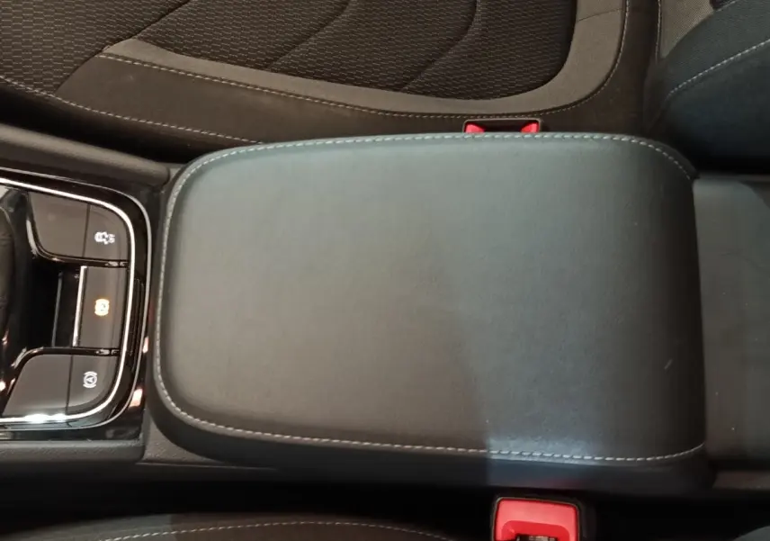 Accoudoir central noir avec coutures grises et commandes électroniques, intérieur du Skoda Kodiaq 2022.