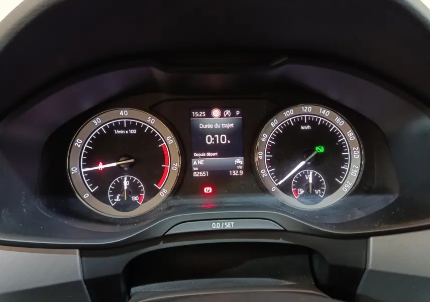 Vue rapprochée du tableau de bord digital du Skoda Kodiaq blanc, affichant compte-tours et vitesse.