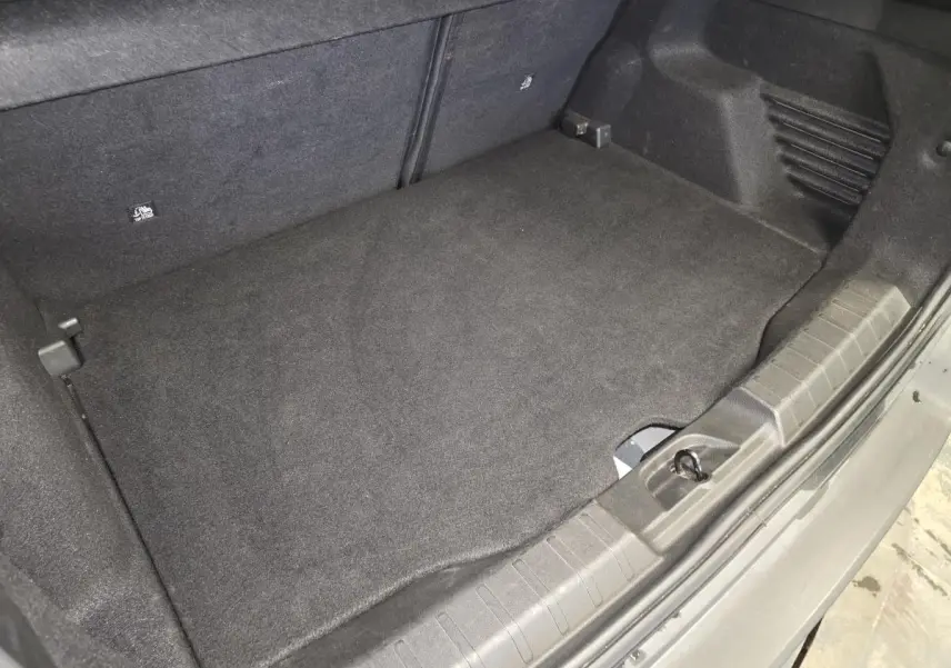 Vue rapprochée du coffre noir du Jeep Avenger 2025, montrant le plancher de coffre modulable et la garniture intérieure.