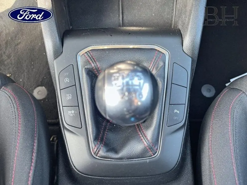 Vue rapprochée du levier de vitesses manuel en cuir noir avec surpiqûres rouges de la Ford Focus gris lunaire 2019.