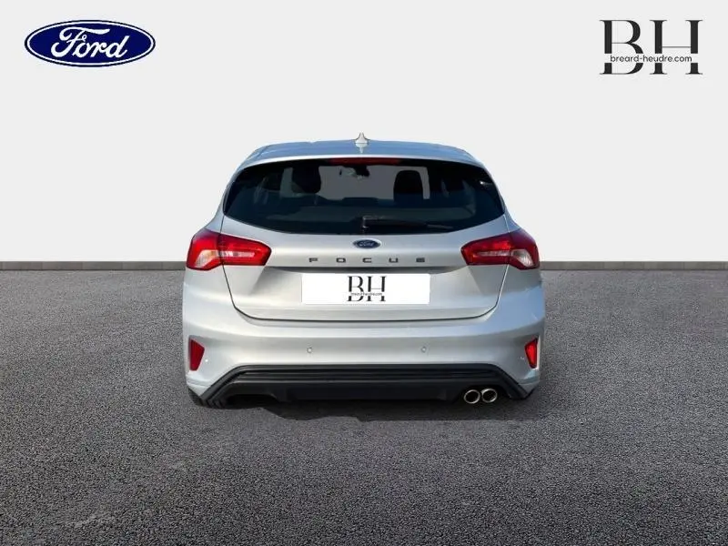 Vue arrière d'une Ford Focus gris lunaire 2019 avec double sortie d'échappement et feux arrière LED distinctifs.