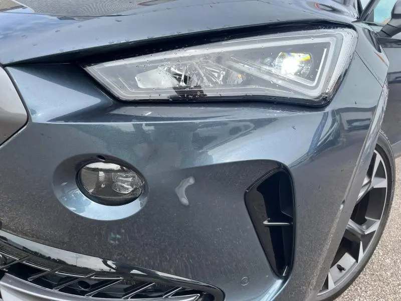 Gros plan sur le phare avant droit et la calandre du CUPRA Formentor gris magnétique métallisé 2024.