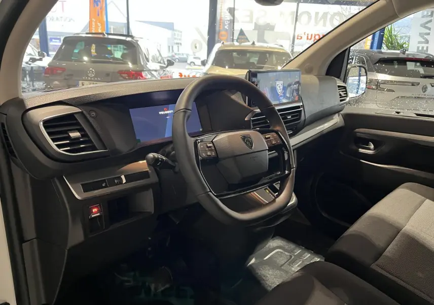 Intérieur du Peugeot Expert Fourgon 2024 vu côté conducteur, volant cuir, tableau de bord numérique et écran tactile.