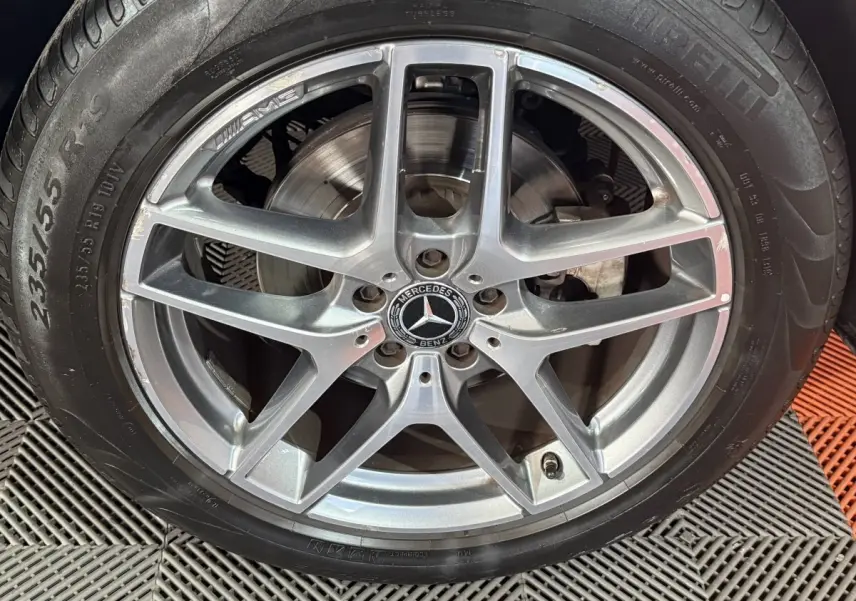 Gros plan sur la jante AMG argentée et le pneu Pirelli d’un Mercedes GLC 250 Fascination 2019 gris foncé.