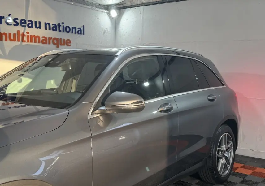 Vue côté droit avant d'un Mercedes GLC 250 Fascination 4Matic gris foncé avec rétroviseur chromé et jantes alliage.