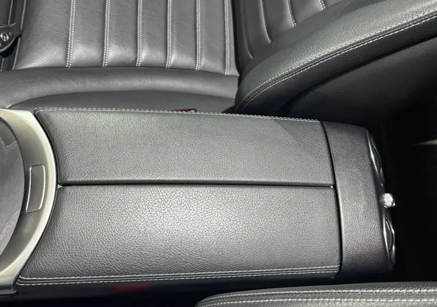 Gros plan sur l'accoudoir central en cuir noir avec surpiqûres blanches de la Mercedes GLC 250 Fascination 2019.