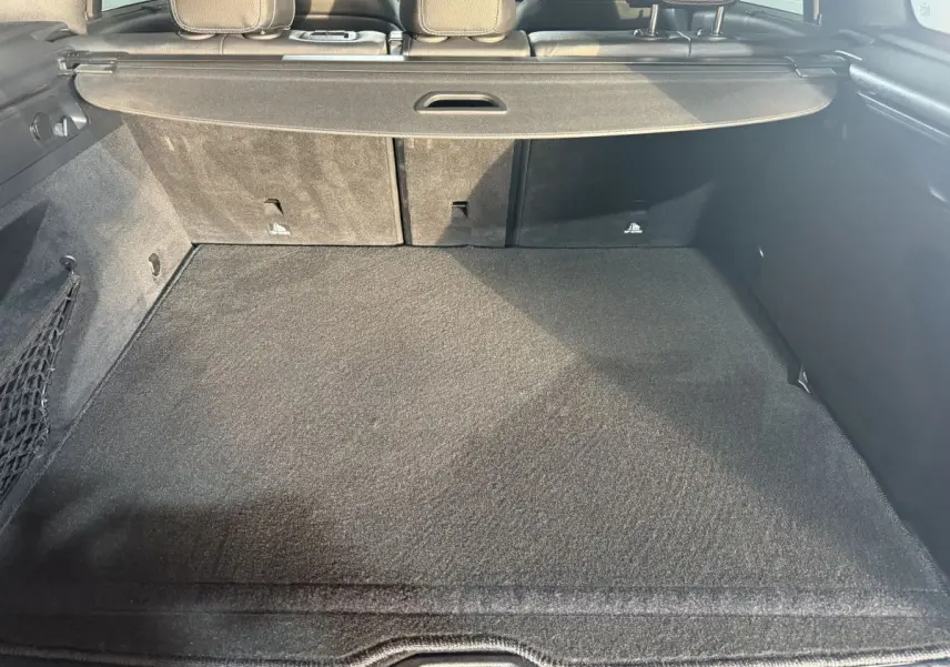 Coffre spacieux vu de l’arrière d’un Mercedes GLC 250 Fascination 4Matic gris foncé, avec cache-bagages déployé.