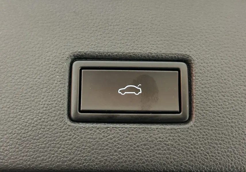 Bouton intérieur noir avec symbole blanc d'ouverture de hayon électrique sur Volkswagen T-Roc noir.