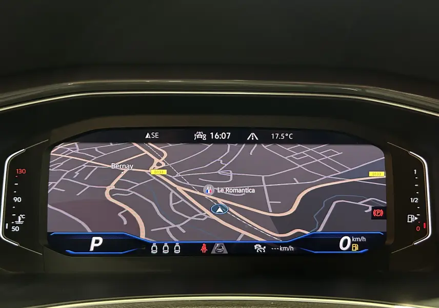 Affichage numérique du tableau de bord du Volkswagen T-Roc noir, montrant la navigation et les informations de conduite.