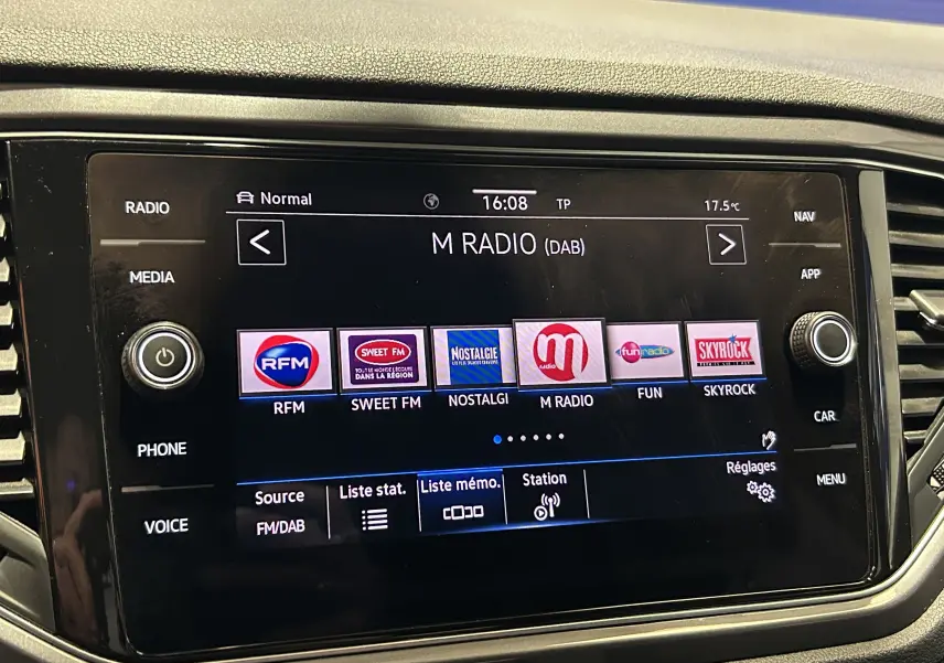 Vue rapprochée de l’écran tactile multimédia noir du Volkswagen T-Roc affichant les stations radio numériques.