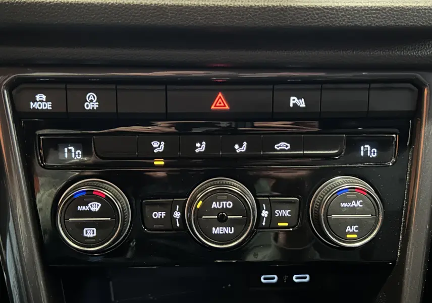 Tableau de bord noir du Volkswagen T-Roc 2020, vue rapprochée sur la console de climatisation digitale et boutons.