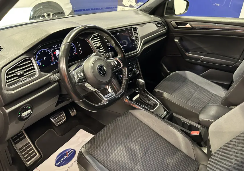 Intérieur noir du Volkswagen T-Roc 2020, vue côté conducteur montrant le tableau de bord et la console centrale.
