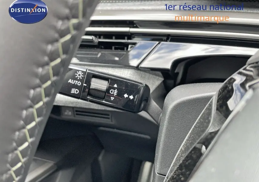 Gros plan sur la commande des feux et clignotants côté gauche du volant d’un Peugeot 5008 blanc toit noir 2025.