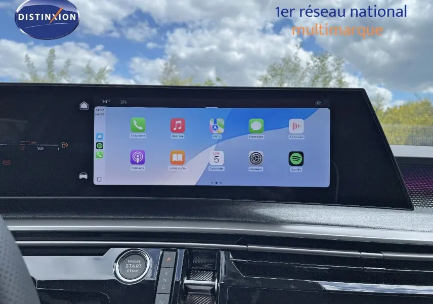 Vue intérieure du tableau de bord du Peugeot 5008 Hybrid 2025 avec écran tactile affichant des applications et bouton start/stop.