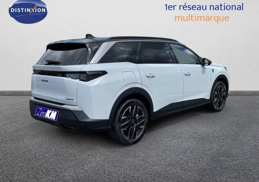 Peugeot 5008 Hybrid 136ch GT blanc Okenite métal avec toit noir, vue 3/4 arrière côté droit sur sol gris.