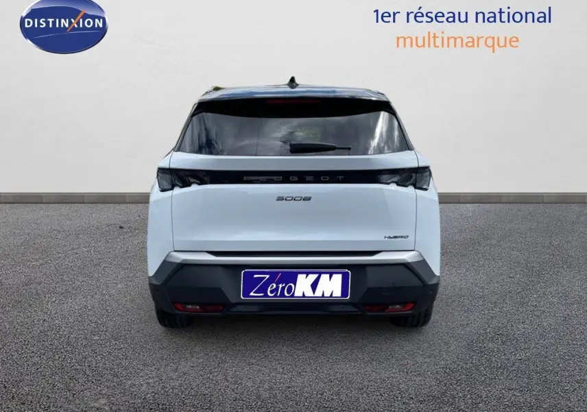 Vue arrière d'un Peugeot 5008 hybride blanc Okenite métal avec toit noir, immatriculé Zéro KM, sur sol gris.