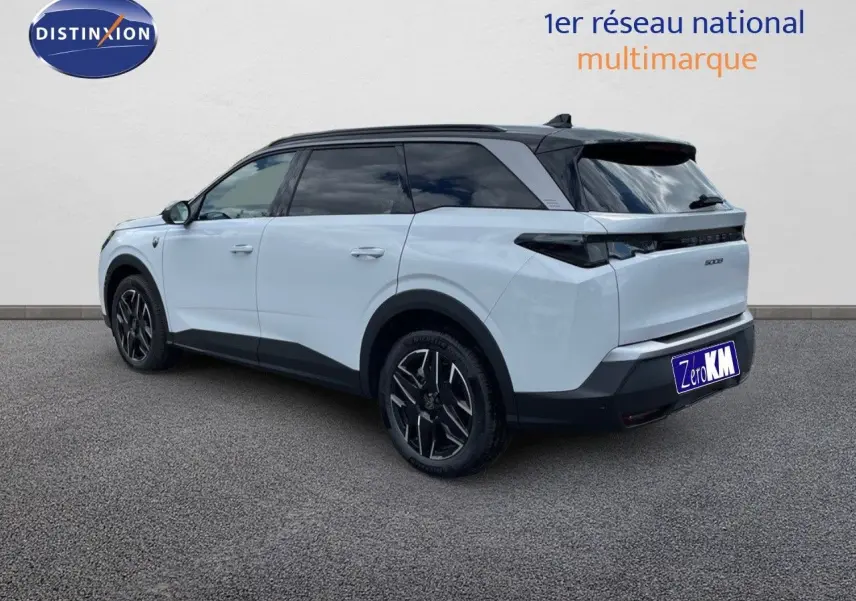 Peugeot 5008 Hybrid 136ch GT blanc Okenite métal avec toit noir, vue 3/4 arrière côté gauche sur sol gris.