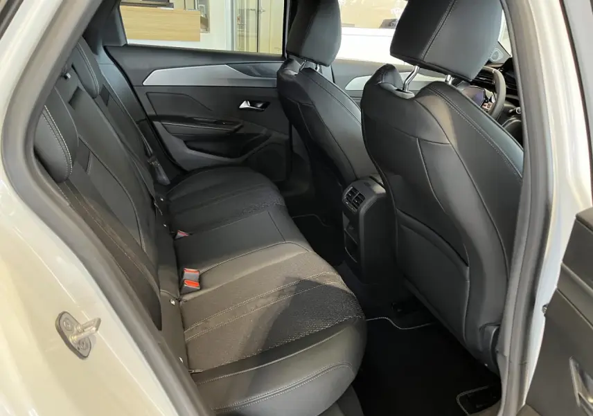 Vue intérieure côté gauche des sièges arrière noirs en cuir et tissu de la Peugeot 308 SW blanc okenite 2025.