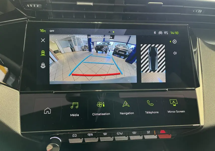 Écran tactile central de la Peugeot 308 SW blanc okenite montrant la caméra de recul en intérieur de garage.