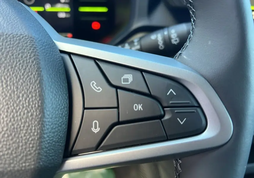 Boutons de commande multifonctions sur le côté droit du volant du Dacia Duster blanc glacier 2025, version Journey Plus.