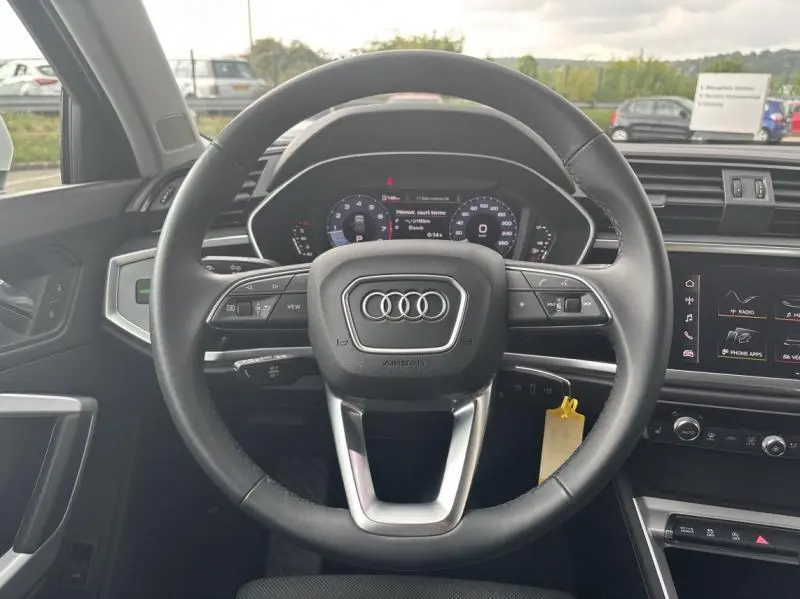 Vue frontale du volant cuir multifonctions de l'Audi Q3 35 TFSI 2022 avec tableau de bord numérique et écran tactile.
