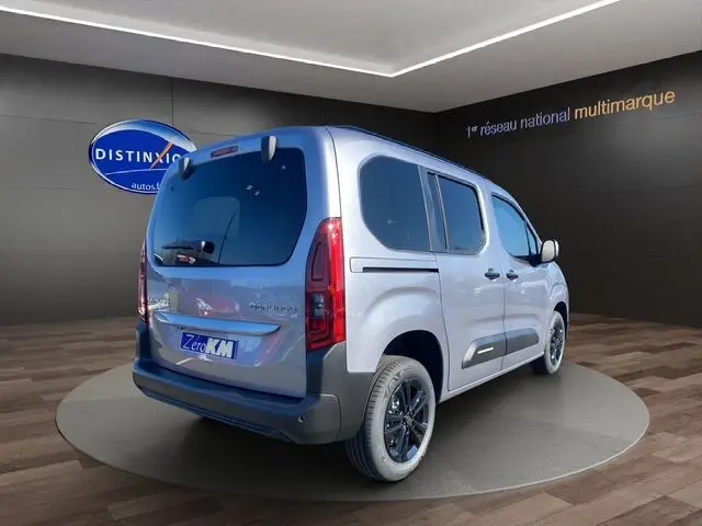 Vue 3/4 arrière droite d'un Citroën Berlingo gris Artense avec jantes alliage noires et vitres teintées.