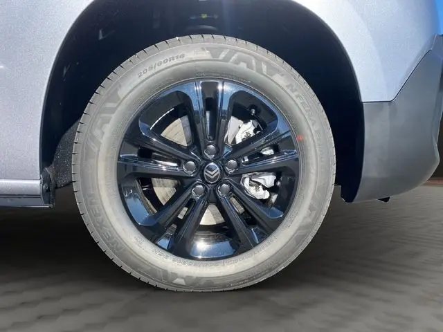 Gros plan sur la roue avant gauche et l'aile gris Artense du Citroën Berlingo 2025, avec pare-chocs noir.