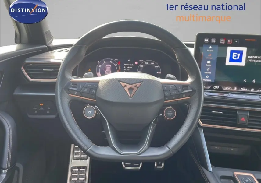 Vue intérieure centrée sur le volant cuir noir et la planche de bord avec écran tactile du CUPRA Formentor blanc neige métal 2025.