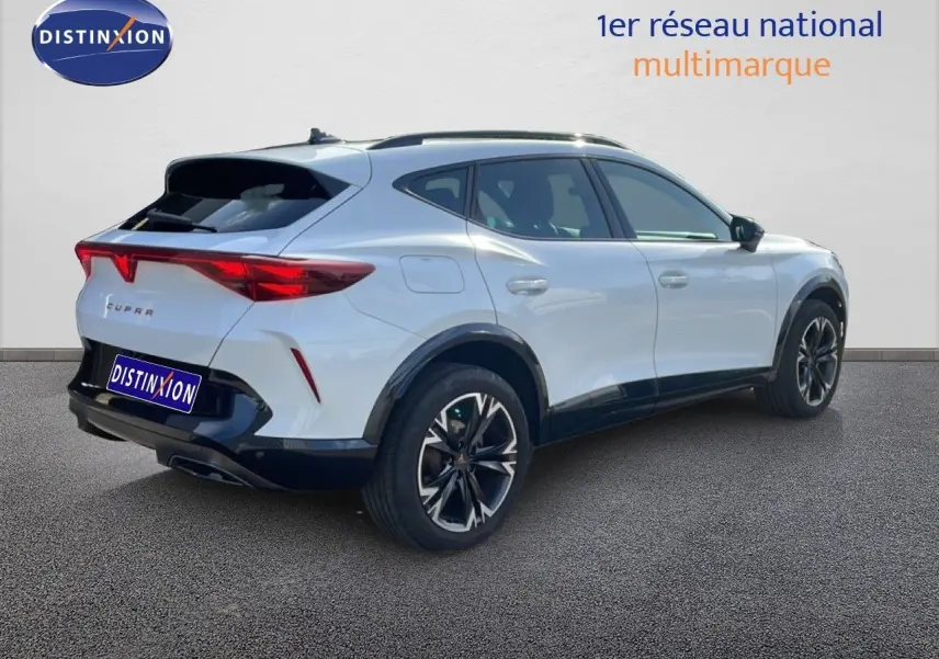 Vue 3/4 arrière droite d'un CUPRA Formentor blanc neige métal avec jantes noires et détails noirs contrastants.