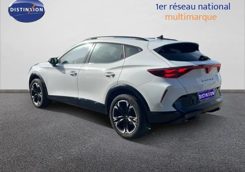 Vue 3/4 arrière droite d'un CUPRA Formentor blanc neige métal avec jantes noires et détails noirs contrastants.