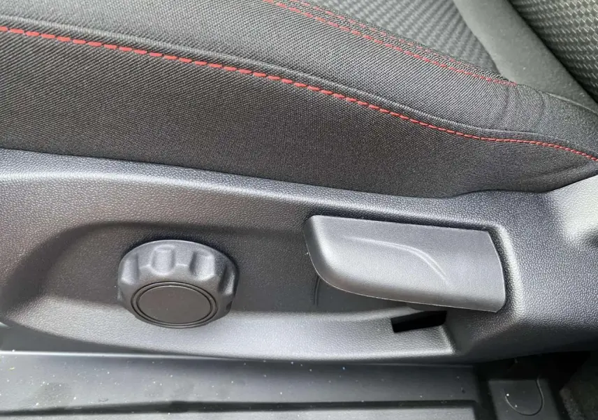 Réglage manuel du siège avant avec tissu noir et surpiqûres rouges dans un Ford Puma Rouge Fantastic 2022.