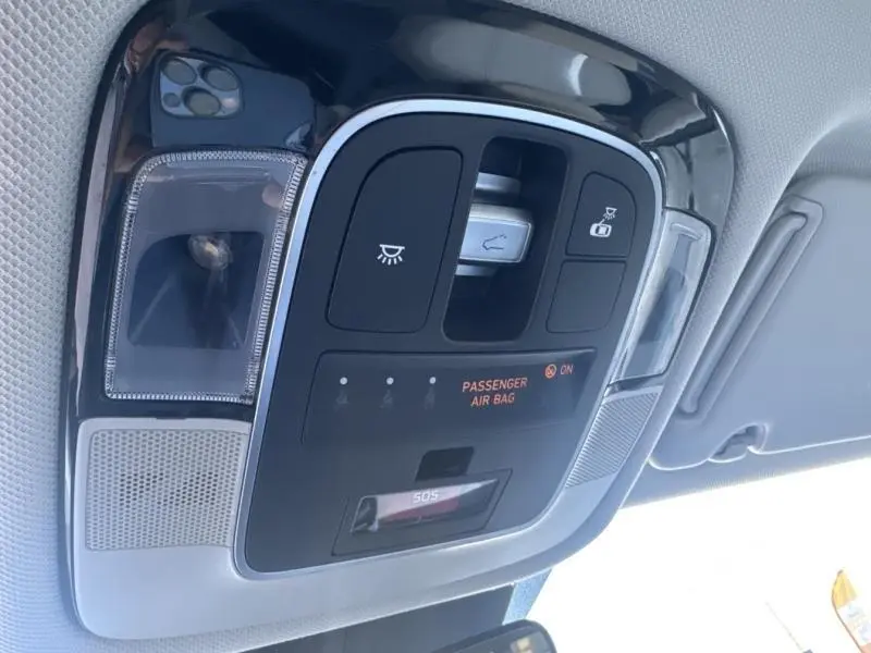 Vue en gros plan du plafonnier intérieur avec commandes d'éclairage et indicateur airbag passager allumé du Hyundai Tucson Teal Blue Métal.