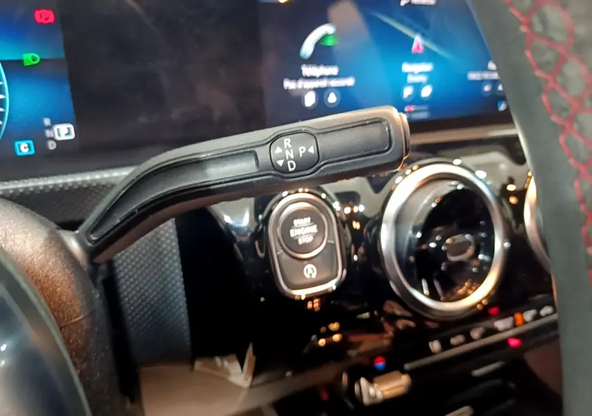 Gros plan intérieur sur la commande de boîte automatique et le bouton start/stop de la Mercedes Classe A noire AMG Line.