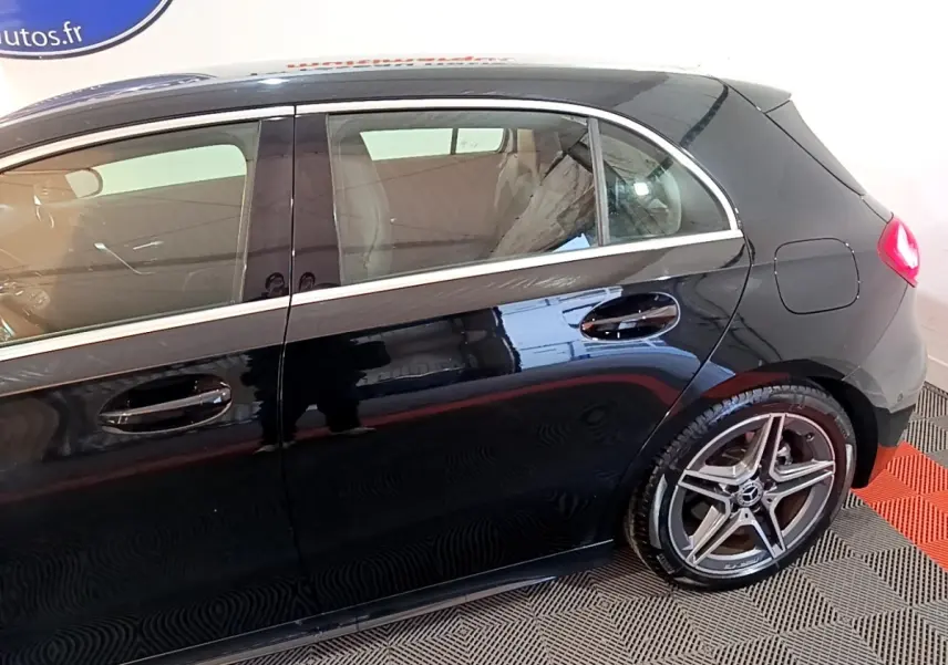 Vue latérale droite d'une Mercedes Classe A A 200 AMG Line noire avec jantes alliage et poignées de porte chromées.