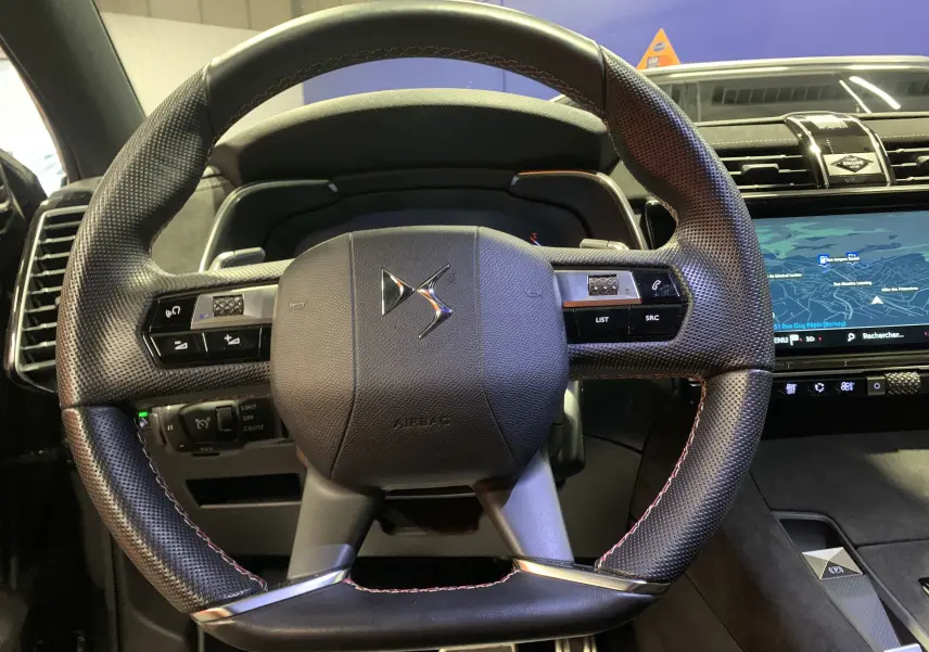 Gros plan sur le volant en cuir perforé avec logo DS, tableau de bord numérique et écran tactile du DS7 Crossback 2022.