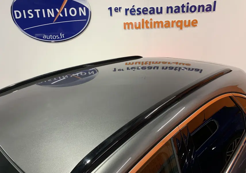 Toit panoramique noir brillant du DS7 Crossback gris Platinium vu en plongée côté gauche, avec reflet du logo Distinxion.