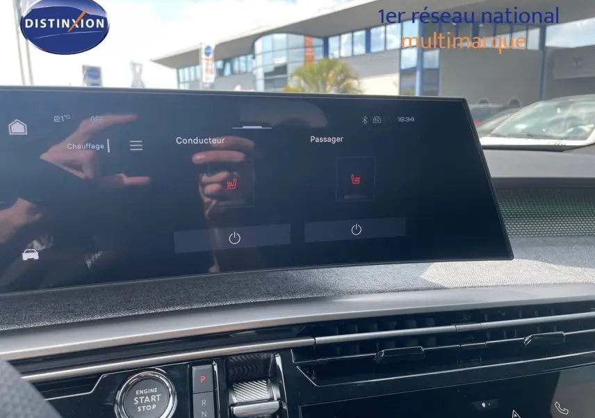 Vue intérieure du tableau de bord du Peugeot 5008 Hybrid 2025, écran tactile affichant le chauffage des sièges.