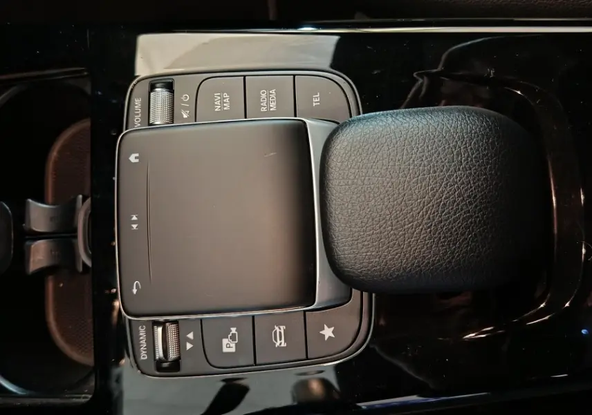 Vue plongeante sur la console centrale noire de la Mercedes Classe A 250 e avec pavé tactile et clé sur siège cuir noir.